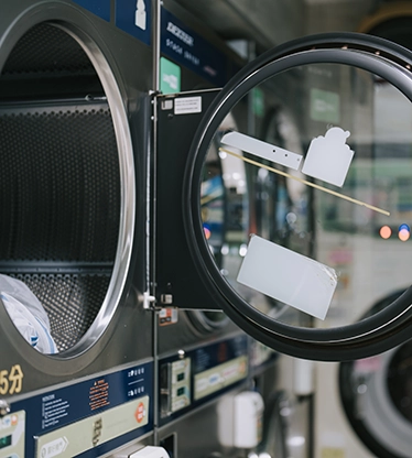 Close up of open dryer door in a laundromat.