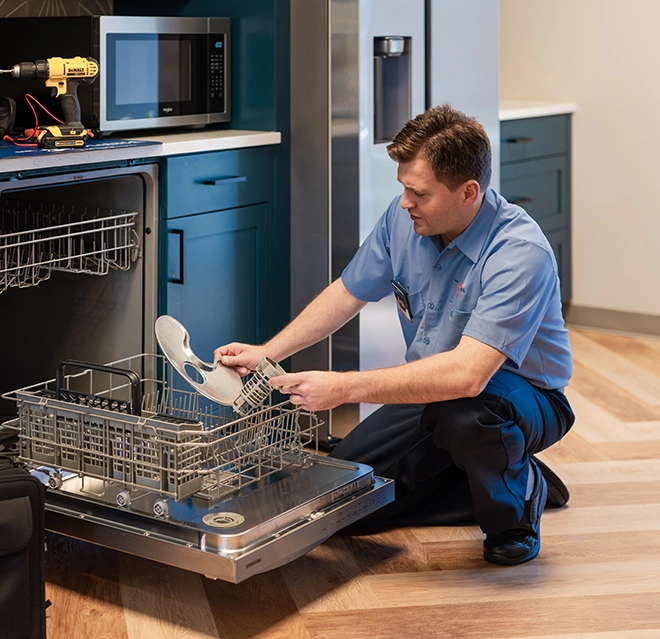 Mr. Appliance service professional examining parts of a dishwasher.