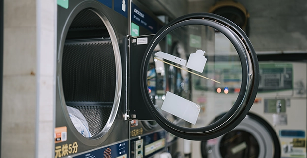 Close up of open dryer door in a laundromat.