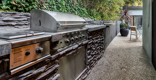Close up of silver grill in outdoor kitchen.