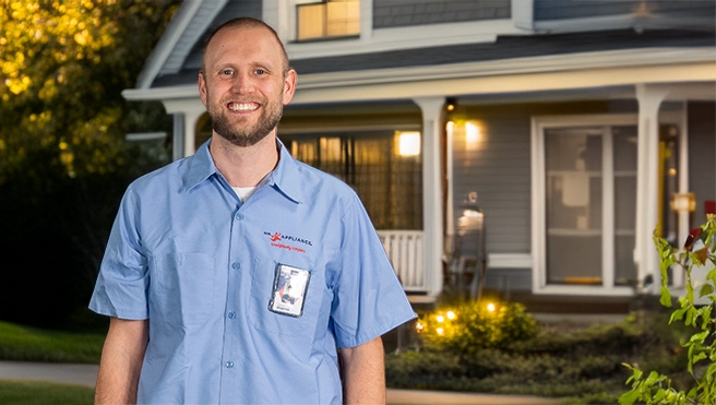 Mr. Appliance service professional smiling in front of a house.