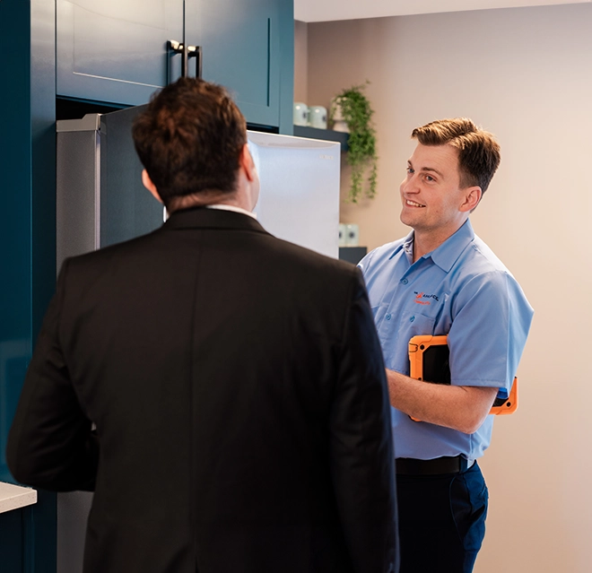 Mr. Appliance service professional smiling while talking to customer.