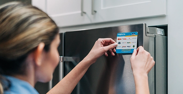 Mr. Appliance service professional applying brand sticker on front of refrigerator.