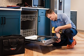 Mr. Appliance service professional reviewing inside of a dishwasher.