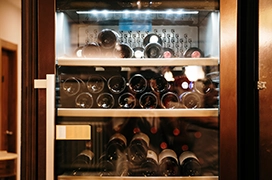 Wine cooler fridge full of bottles of wine.