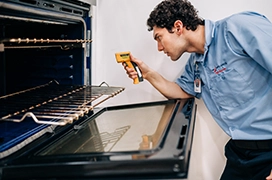 Mr. Appliance service professional reviewing inside of an oven.