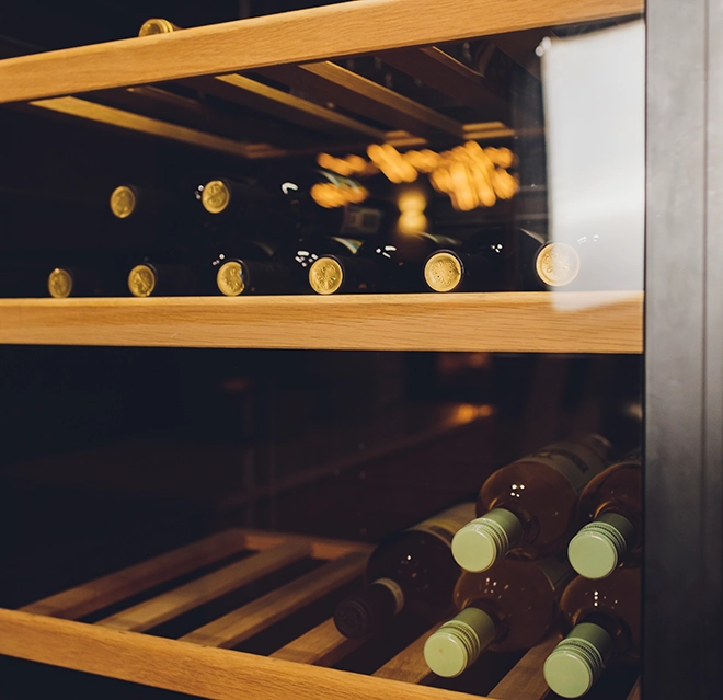 Wine bottles inside a wine cooler.