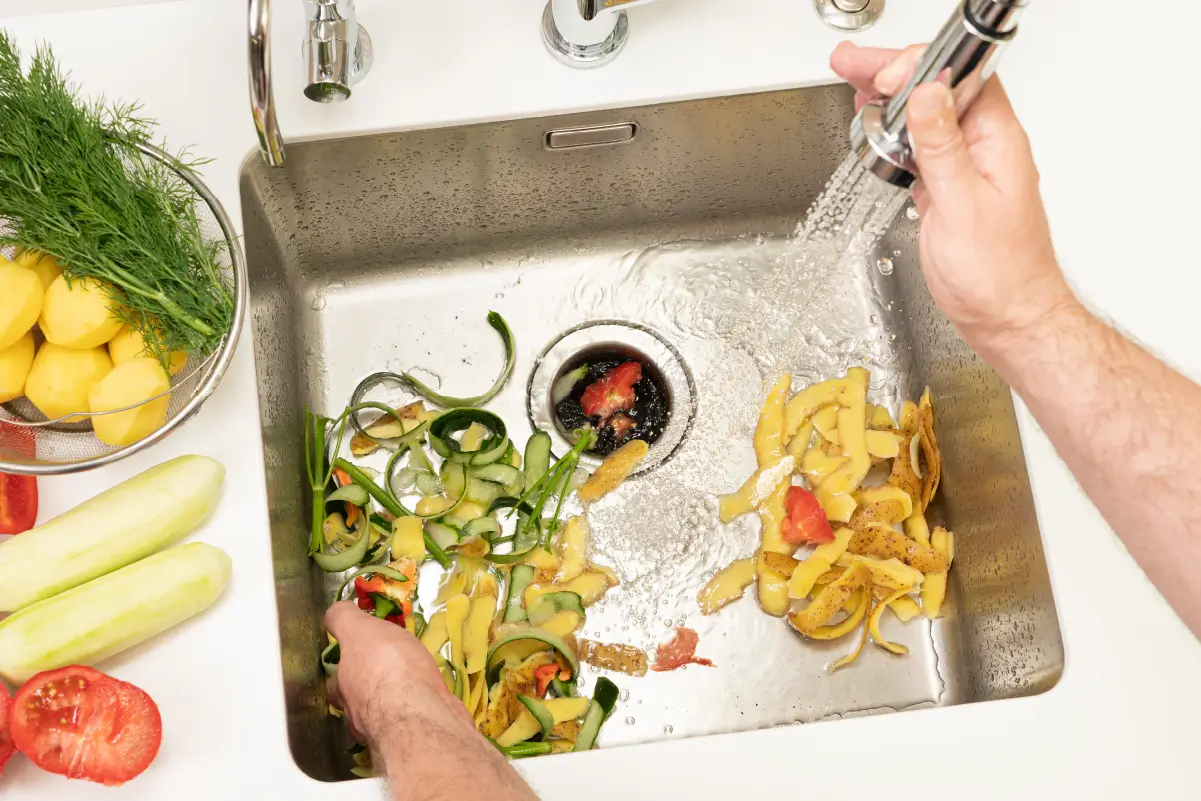 Kitchen sink filled with food scraps.