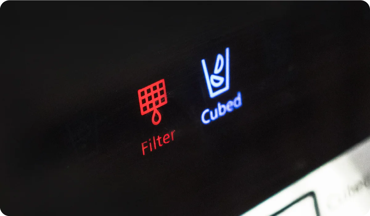 Close-up of the red water filter sign lit up on a refrigerator
