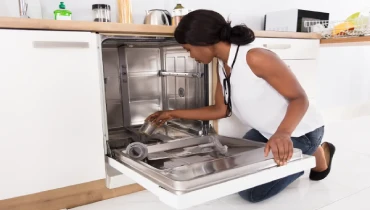 Woman cleaning the filter to remove dishwasher smells
