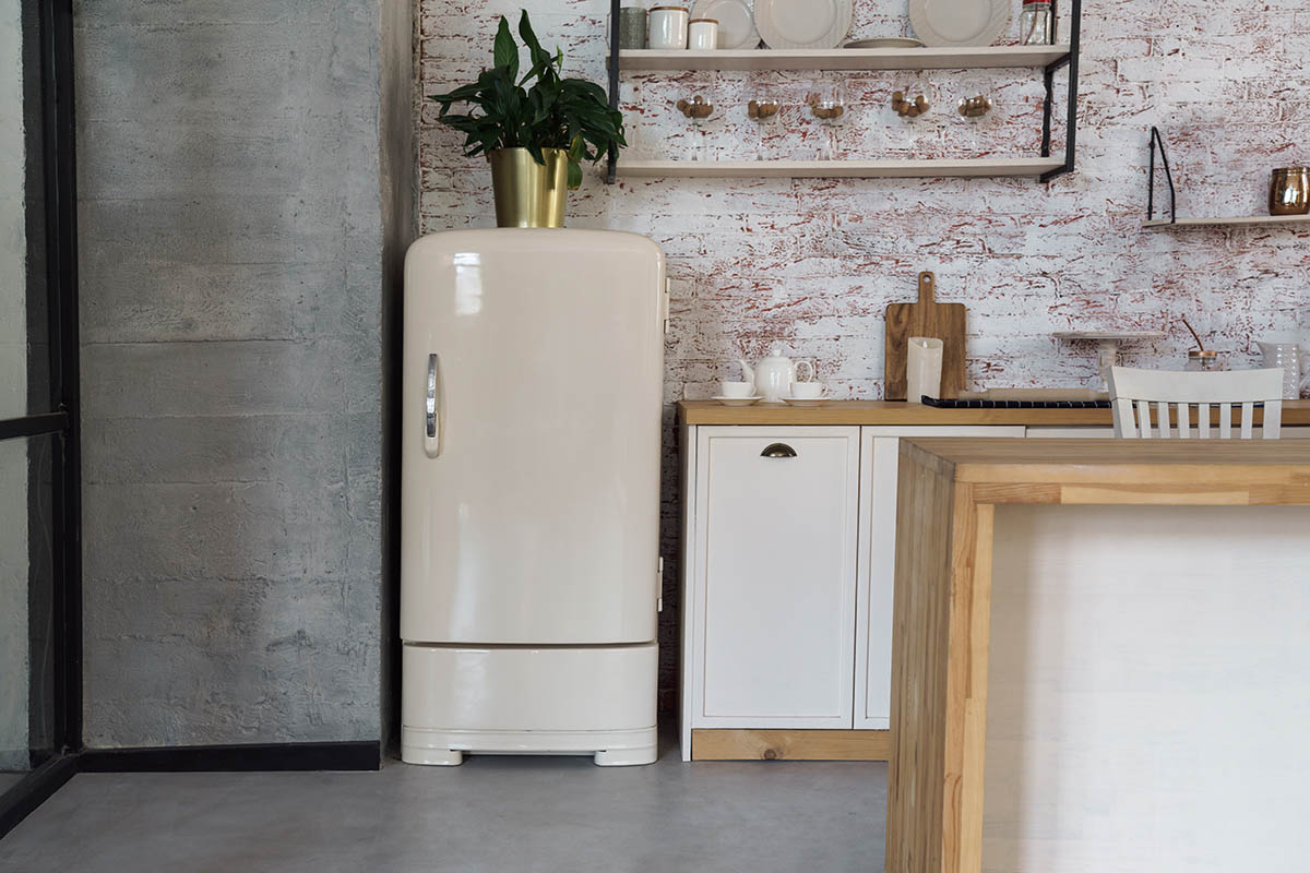 Cream-colored vintage fridge in an industrial kitchen.