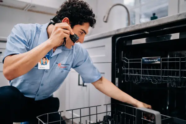 A Mr. Appliance service professional diagnosing a dishwasher issue.