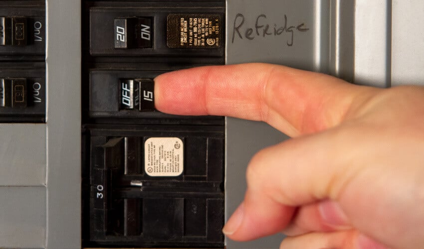 Finger pressing buttons on appliance.
